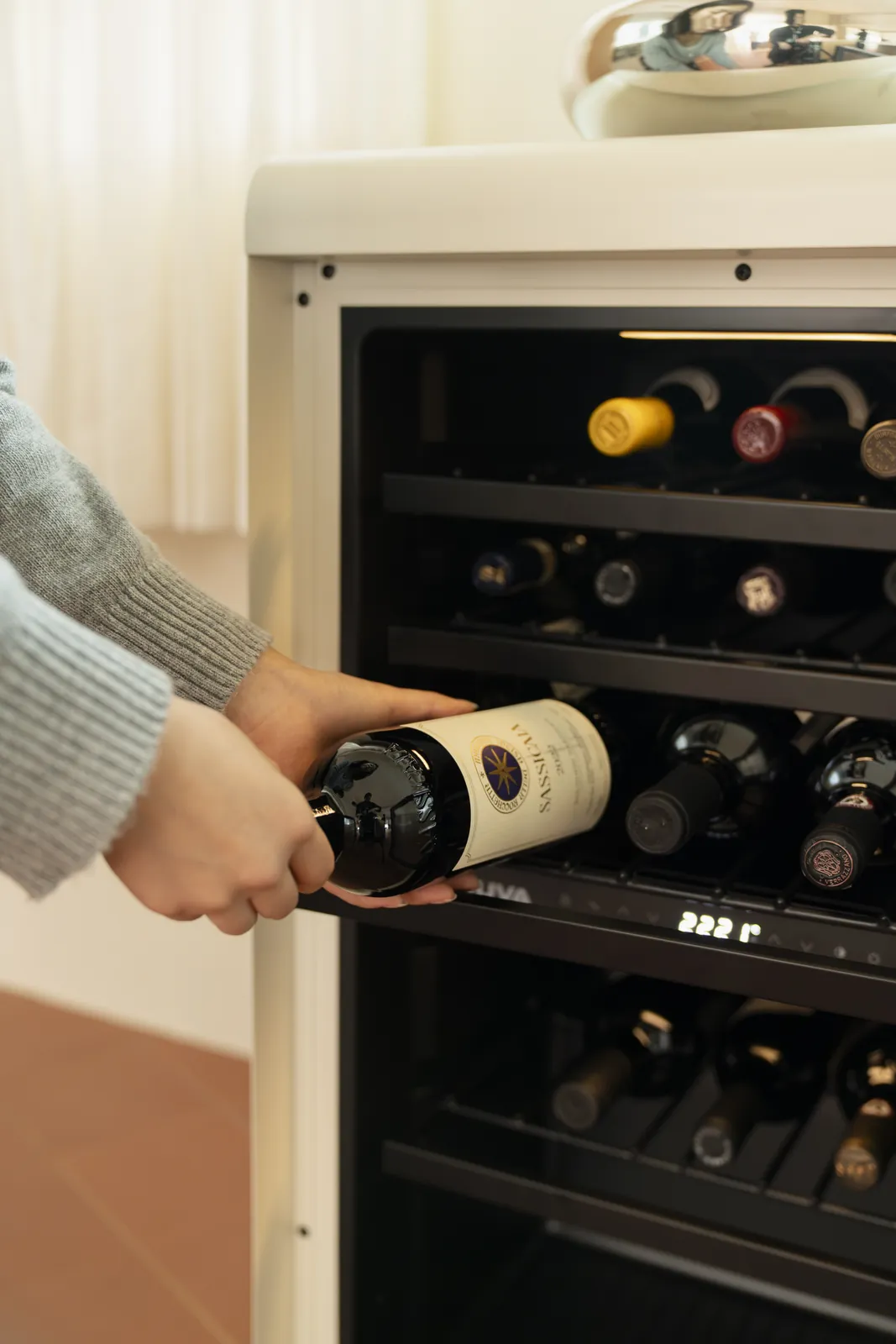 A hand taking a bottle from the shelf
