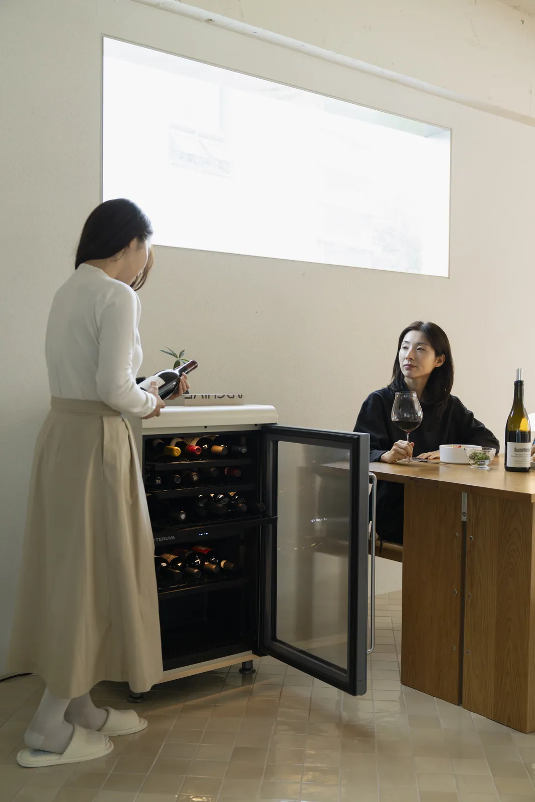 Choosing a bottle from the wine cellar beside the dining table